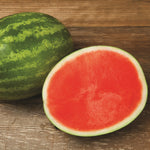 Whole and half watermelon on a wooden surface